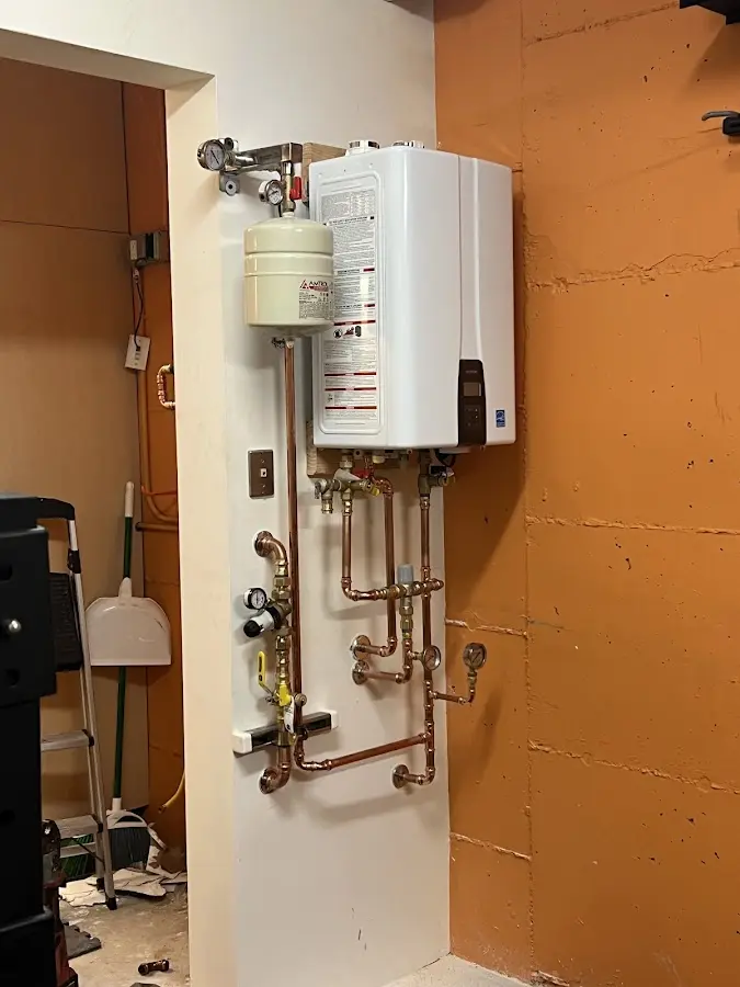 Plumbing technician inspecting water heater connections in South Union